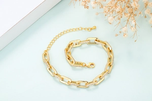 Detailed shot of 18K gold rectangle chain bracelet with pave set cubic zirconia crystals