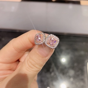 Close-up of square halo earrings with pink cushion-cut zircon in rose gold and silver settings