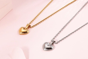 Macro detail of gold and silver heart necklaces with beaded edge and twisted chain