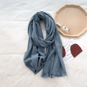 Detail of soft dark grey blue cashmere scarf featuring delicate short fringe tassels