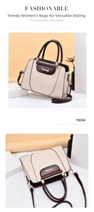Close-up of cream handbag with dark brown handles and golden hardware details