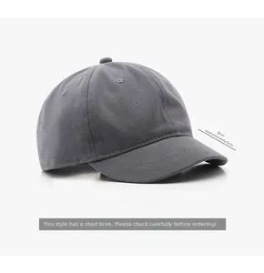 Détail d'une casquette de baseball grise en coton montrant la visière courte de 5 cm