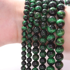 Natural green tiger eye stone bracelets in various bead sizes on a model's wrist