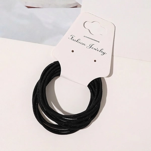 Macro shot of thin black elastic hair ties with subtle glitter texture on a display card