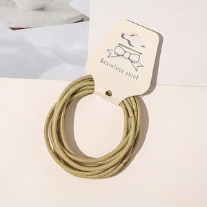 Detail of high-elasticity golden hair ties with metallic woven texture on display card