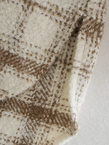 Gros plan sur la texture du tissu en laine à carreaux marron et blanc pour chemise