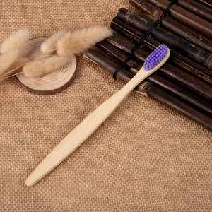 Eco-friendly bamboo toothbrush with purple bristles on a rustic linen and wood background