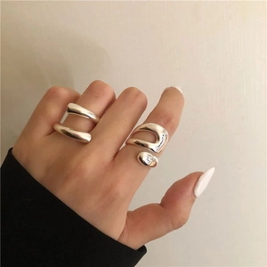 Detailansicht silberner geometrischer Ringe mit abstraktem Metall-Layer-Design