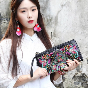 Close-up of intricate floral embroidery and silk texture on black ethnic clutch bag