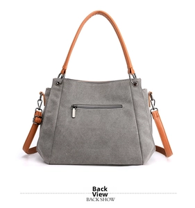 Gray canvas tote bag back view with brown leather handles and a metal zipper pocket