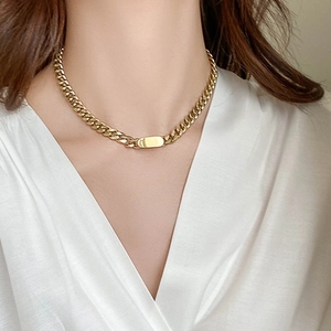 Golden Cuban chain titanium steel necklace with rectangular pendant worn by a model