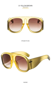 Detail view of large yellow transparent frame sunglasses with brown gradient lenses