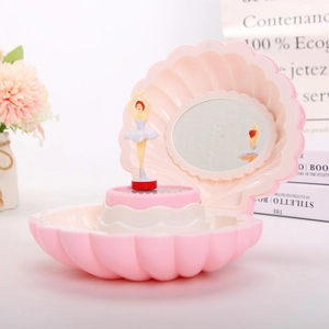 Pink shell musical jewelry box with rotating ballerina and mirror in a soft floral setting