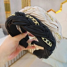 Detailansicht von gewebten Haarreifen in Beige und Schwarz mit goldener Kettenverzierung