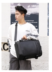 Man carrying a versatile black waterproof travel bag in a modern urban street setting
