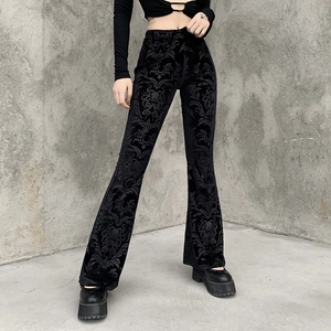 Detail of high-waist flared pants featuring black velvet floral jacquard and dark vintage pattern