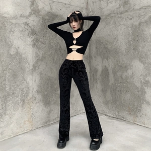 Close-up of black flared trousers featuring vintage embossed velvet patterns and textured fabric