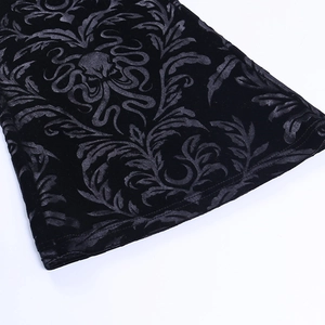 Detail of black velvet trousers featuring embossed Gothic skull and Damascus patterns