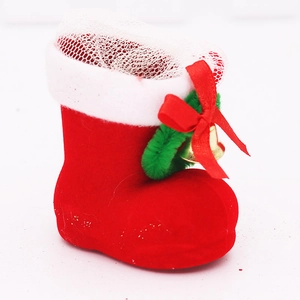 Detail of red flocked Christmas boot with white fur trim, gold bell and red ribbon bow