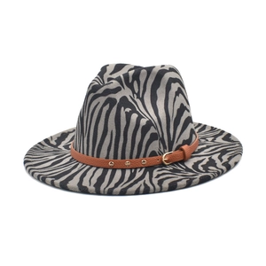 Detail of zebra pattern wool fedora hat with brown leather belt and metal studs