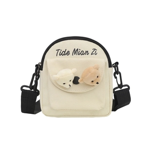 Cute off-white canvas crossbody bag with small bear doll and black shoulder strap
