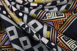 Macro shot of colorful geometric jacquard weave texture on a bohemian tassel scarf