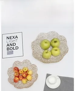 Top view of two gold wire fruit baskets with wavy mesh edges and fresh apples