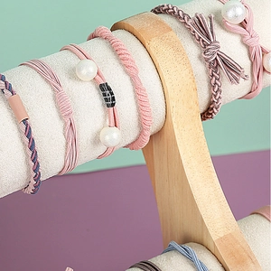 Solid wood jewelry display stand with colorful elastic pearl hair ties and braided ropes