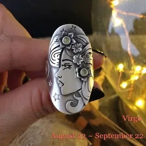 Macro shot of vintage silver Virgo zodiac ring featuring green gems and flower engraving