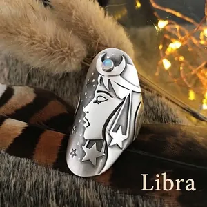 Detailed view of Libra zodiac ring with embossed moon star pattern and opal gemstone