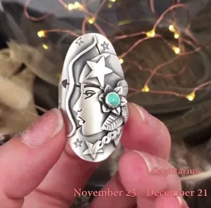 Macro shot of vintage Sagittarius ring with turquoise stone and celestial relief engraving