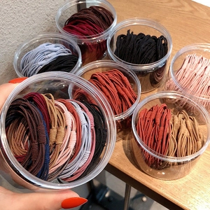 Multiple containers of premium elastic hair ties in various colors for women's hair styling