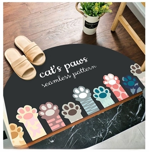 Detailed top view of a semi-circular cat paw pattern door mat on a wooden floor