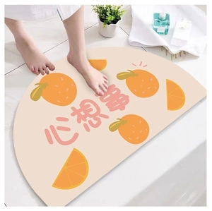 Detailed view of semi-circular orange pattern bath mat with non-slip water absorbent texture