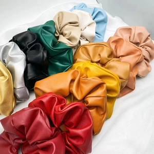 Close-up of assorted colorful PU leather scrunchies with elegant textured finish