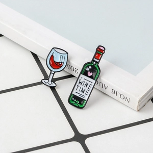 Detail of enamel wine bottle and glass brooch with Wine Time text and heart pattern