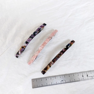 Detailed top view of 10cm acetate hair clips in marble and tortoiseshell patterns