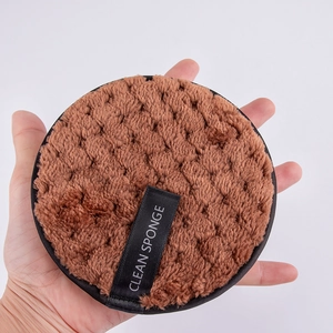 Close-up of brown microfiber cleansing puff with clean sponge label and soft plush texture