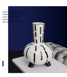 Close-up of minimalist black and white striped ceramic vase with creative three-foot base