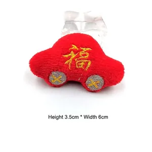 Vue détaillée d'une petite voiture en peluche rouge avec broderie Fu, taille 3,5 cm sur 6 cm