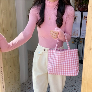 Close-up of pink checkered cotton linen tote bag styled with a matching knit sweater