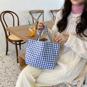 Blue and white plaid cotton linen handbag shown in a lifestyle cafe setting