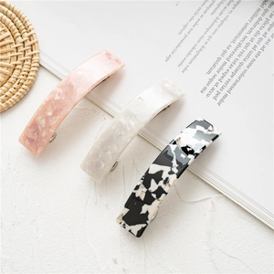 Three-piece acetate spring hair clips set in pink, white, and black marble patterns