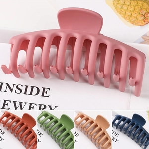 Macro view of large matte hair claws in multiple colors like pink, green and navy blue