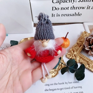 Macro detail of a handmade knitted Christmas gnome with grey hat and white beard