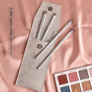 Détail du set de 4 pinceaux à paupières argentés et pochette sur tissu de soie rose