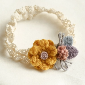 Handmade baby lace headband with colorful wool felt flowers on a soft cream elastic band