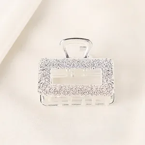 Detailed macro of silver alloy hair claw featuring an elegant embossed rose floral pattern