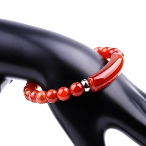 Detailed view of red agate bead bracelet with silver accent on a display hand
