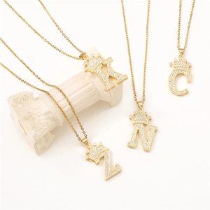 Gold plated crown letter necklaces K, N, C, Z with zircon inlay on white marble pillar
